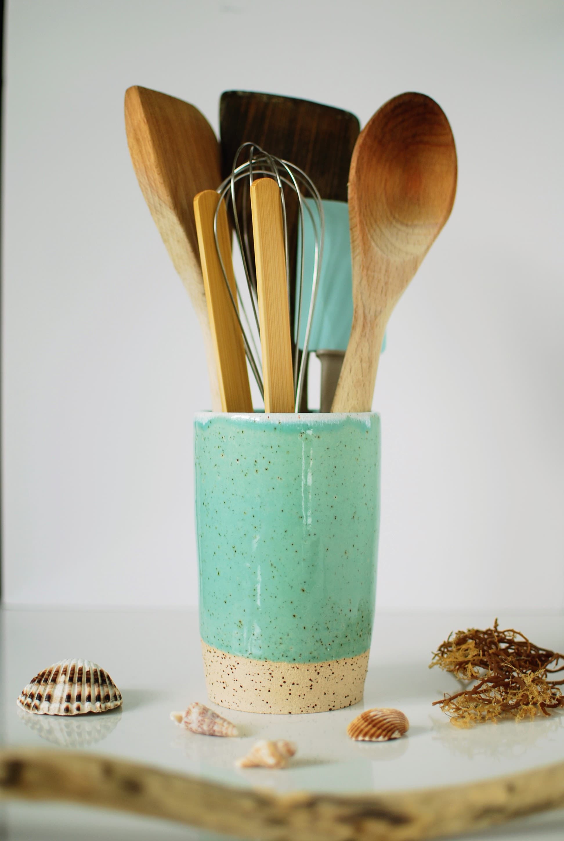 Stoneware utensil holder with turquoise speckled glaze filled with wooden spoons and kitchen tools — Maguelone collection, handmade ceramics by Studio Lippi Ceramics in Dublin, Ireland